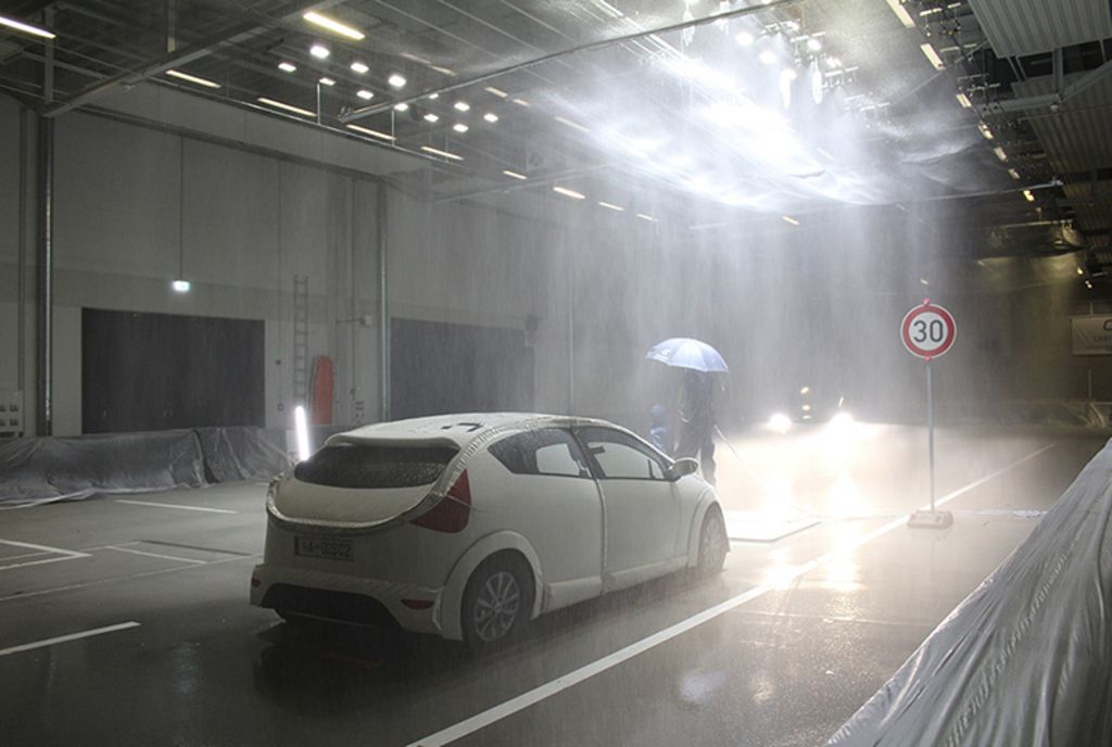 Ein Auto beim Testfahren in einer Halle im Regen
