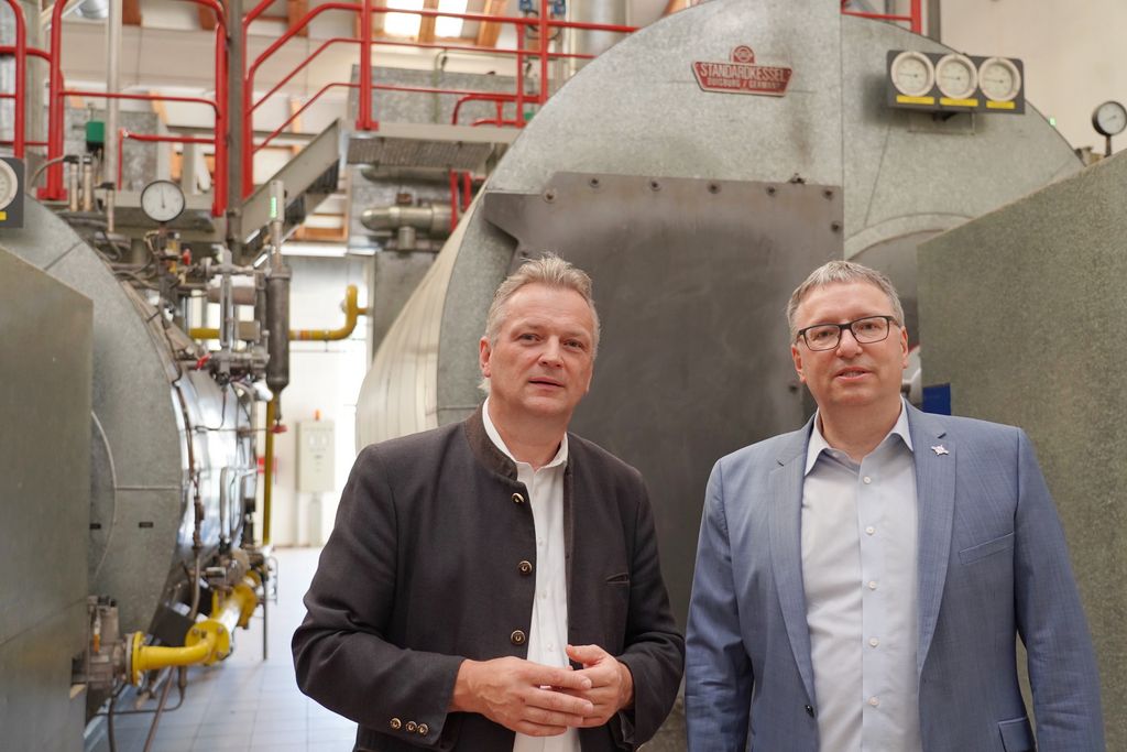 Staatssekretär Roland Weigert (l.) und Südstärke-Geschäftsführer Dr. Stefan Dick vor dem Dampfkessel im Schrobenhausener Werk, der mit Flexi-Brenner betrieben wird.