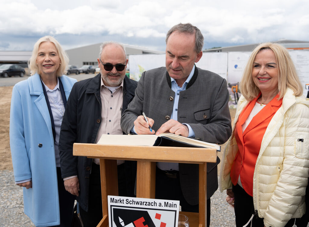 Nach dem Spatenstich trug Minister Aiwanger sich in das Goldene Buch der Gemeinde Schwarzach ein. Das Bild zeigt (v.l.n.r.): Regierungspräsidentin des Bezirks Unterfranken, Susanne Weizendörfer; Schwarzachs Bürgermeister Volker Schmitt, Staatsminister Hubert Aiwanger und die Landrätin des Landkreises Kitzingen, Tamara Bischof. Foto: StMWi/K. Huber