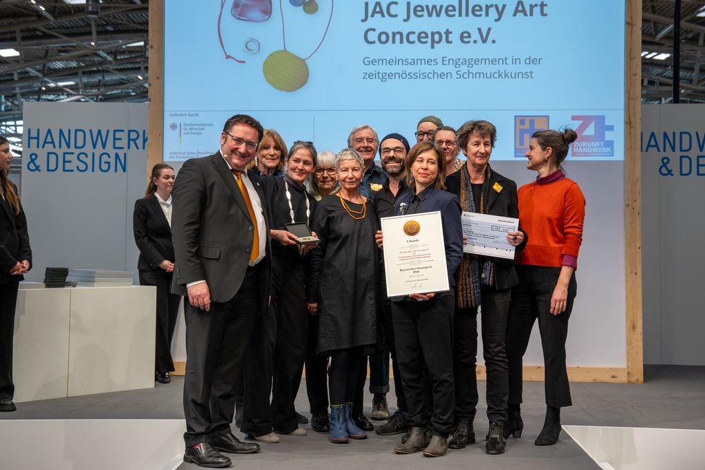 Bayerns Wirtschaftsstaatssekretär Tobias Gotthardt übergibt den Staatspreis an JAC Jewellery Art Concept e.V..