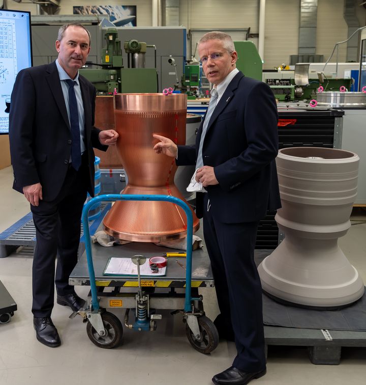 Dr. Gerald Hagemann (Standortleiter Ottobrunn der ArianeGroup GmbH) zeigt Bayerns Wirtschaftsminister Aiwanger in Taufkirchen/Ottobrunn Hightech-Triebwerktechnologie &quot;made in bavaria&quot;. (Foto: StMWi / E. Neureuther)