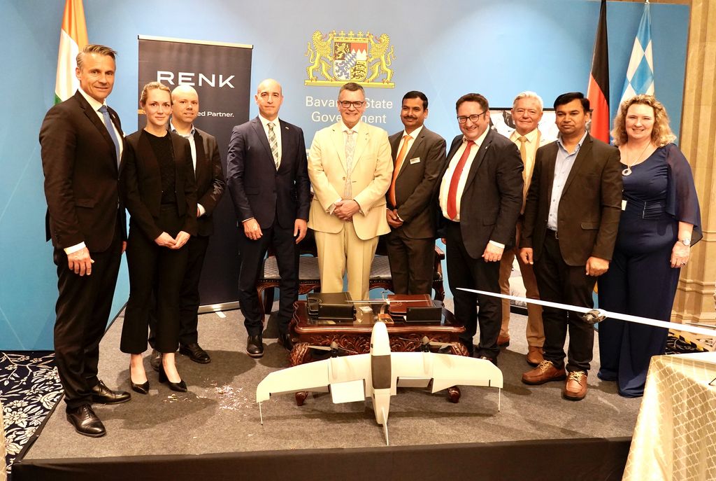 Staatssekretär Tobias Gotthardt (vierter von rechts) und Staatsminister Florian Herrmann (Mitte) bei der Unterzeichnung in Bangalore.Links und rechts von Staatsminister Herrmann die Vertreter von Quantum Systems (Martin Karkour, Chief Sales Officer) und RENK (Praveen Mohan, Geschäftsführer RENK India). Foto: StMWi