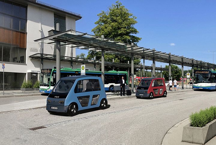 Bild eines futuristischen Autos vor einer Bushaltestelle.