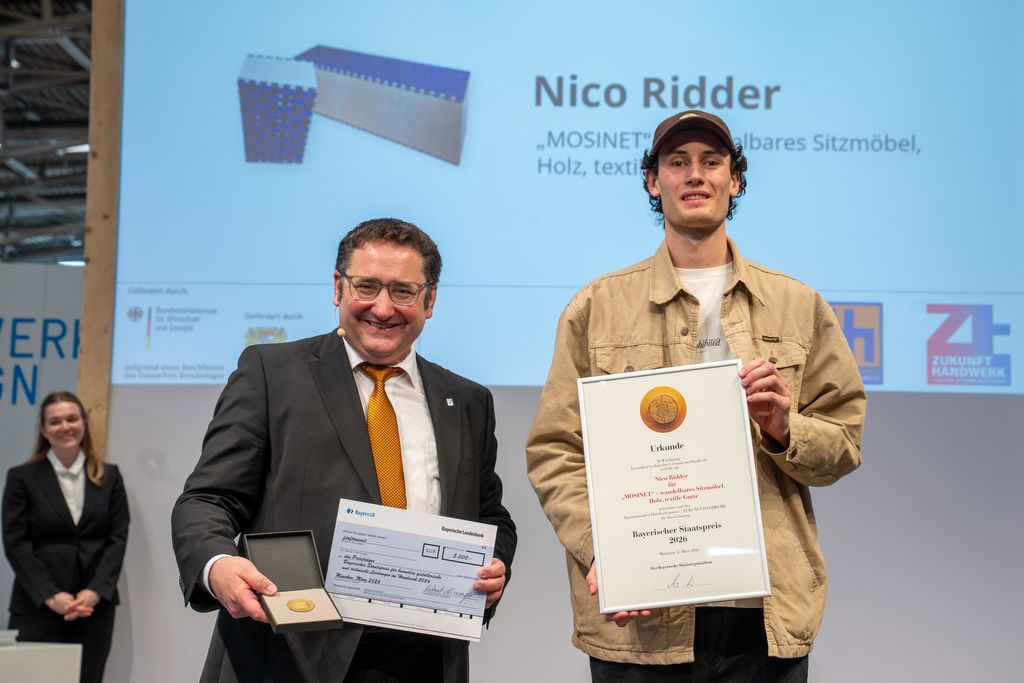 Bayerns Wirtschaftsstaatssekretär Tobias Gotthardt übergibt den Staatspreis an Nico Ridder.