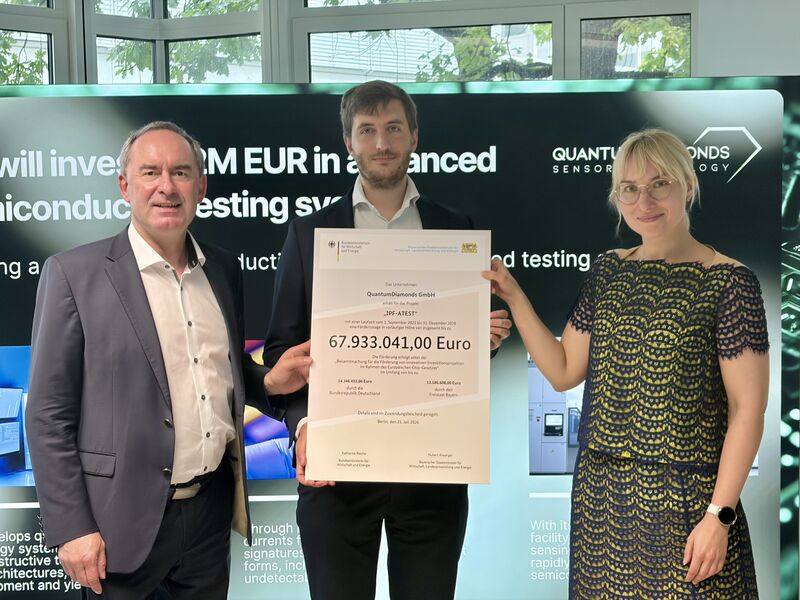 Bayerns Wirtschaftsminister Hubert Aiwanger überreichte den symbolischen Förderbescheid an Dr. Flemming Bruckmaier, CTO und Gründer von Quantum Diamonds. Rechts: Dr. Irina Kerner, Bundeswirtschaftsministerium. Foto: Viola Kemmer/StMWi