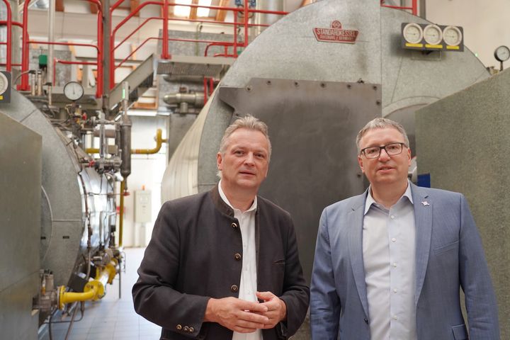 Staatssekretär Roland Weigert (l.) und Südstärke-Geschäftsführer Dr. Stefan Dick vor dem Dampfkessel im Schrobenhausener Werk, der mit Flexi-Brenner betrieben wird.