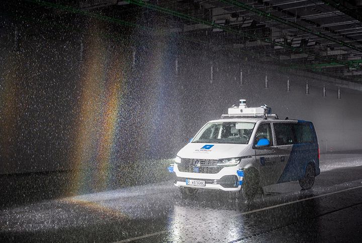 Ein Bus beim Testfahren in einer Halle im Regen