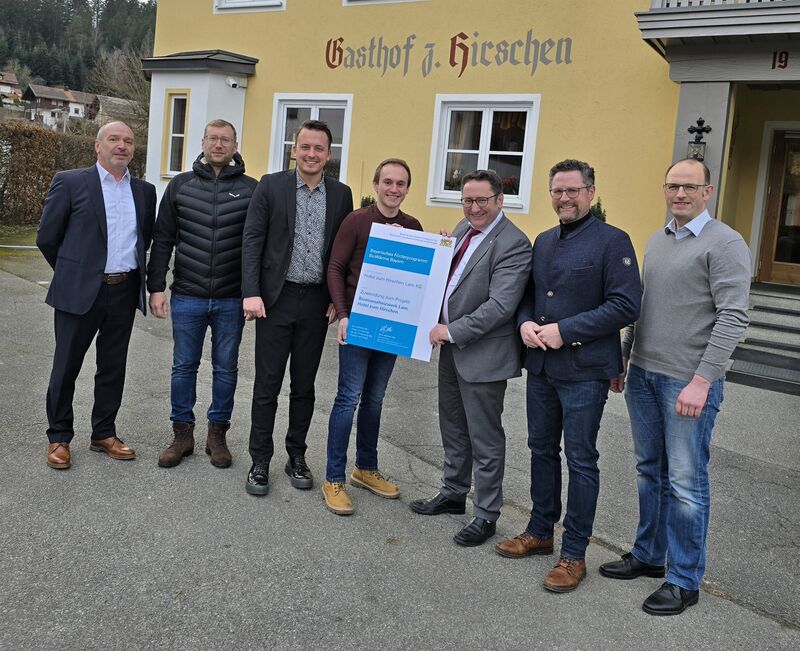 Bayerns Wirtschaftsstaatssekretär Tobias Gotthardt hat das Hotel zum Hirschen in Lam besucht und der Betreiberfamilie Sperl-Vogl eine Förderurkunde für das neue Biomasseheizwerk überreicht. Das Foto zeigt (v.l.n.r): Unternehmensberater Klaus Etzold, Steuerberater Philipp Weininger, MdL Julian Preidl, Hotelbetreiber Andreas Vogl, Staatssekretär Gotthardt, MdL Gerhard Hopp und Energieberater Wolfgang Kuchler. Foto: StMWi