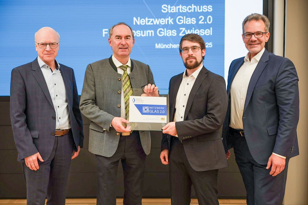 Wirtschaftsminister Hubert Aiwanger übergibt Dr. Tobias Helling, Netzwerkmanager Netzwerk Glas 2.0, ein Türschild. v.l.n.r. Matthias Konrad (Bayern Innovativ), Wirtschaftsminister Aiwanger, Dr. Tobias Helling, Dr. Rainer Seßner (Bayern Innovativ). Foto: StMWi.