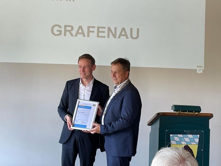 Herr Regierungspräsident Rainer Haselbeck überreicht Herrn Bürgermeister Alexander Mayer die Ernennungsurkunde für die Stadt Grafenau.