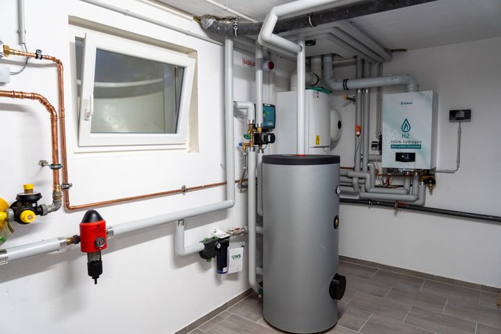 Die hochmoderne Wasserstoff-Brennwerttherme mit Pufferspeicher eingebaut im Keller eines Wohnhauses. Foto: StMWi/E. Neureuther