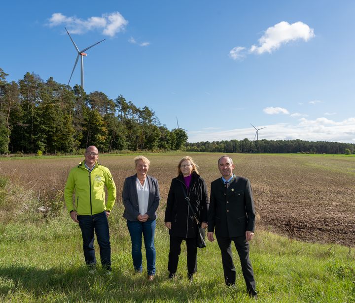 Wirtschaftsminister Hubert Aiwanger gemeinsam mit (v.l.) Stefan Paulus (Projektentwickler Wust Wind &amp; Sonne GmbH &amp; Co. KG), Bürgermeisterin Regina Bruckmann und der Landtagsabgeordneten Gabi Schmidt vor der Ackerfläche, auf der die PV-Freiflächenanlage im Umgriff der bestehenden Windenergieanlage geplant ist. Foto: Elke Neureuther/StMWi
