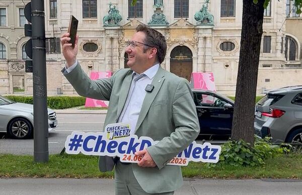 Staatssekretär Tobias Gotthardt hält ein Smartphone in der Hand