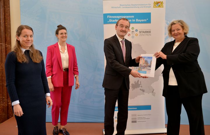 Ministerialdirektorin Dr. Ulrike Wolf überreicht dem Team aus Coburg das Handbuch.
