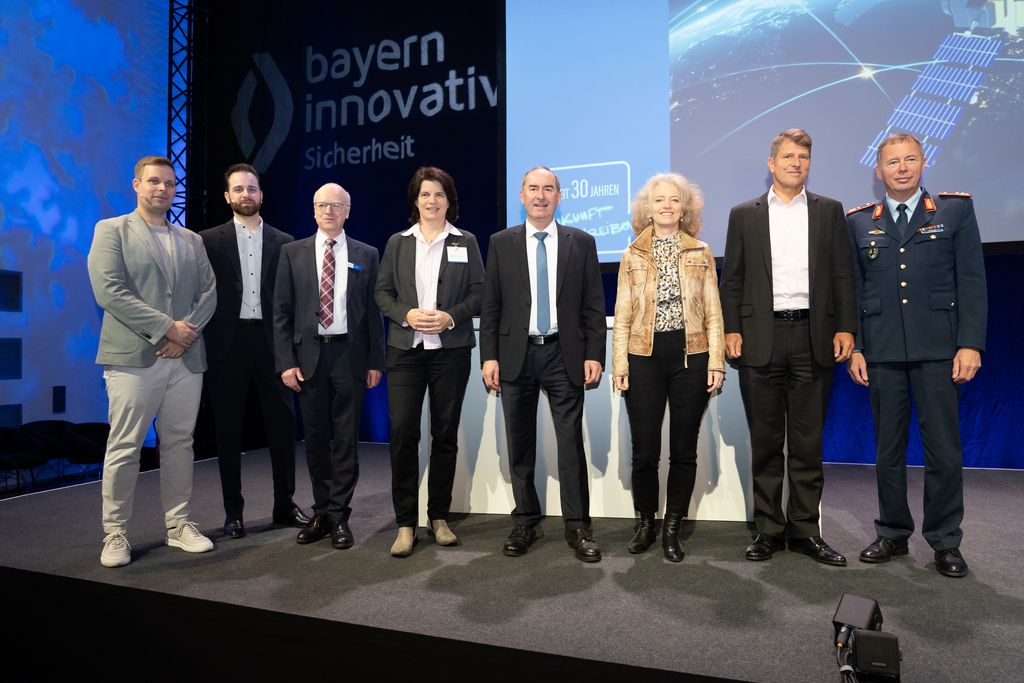 Beim Netzwerkforum "militärische Raumfahrt" kamen viele Akteure zusammen. (v.l.n.r. Christoph Heinen (Leiter TechHUB SVI), Sven Rochier (Projektmanager Bayern Innovativ), Dr. Matthias Konrad (Mitglied der Geschäftsleitung Bayern Innovativ), Ministerialrätin Dr. Claudia Andree (BMFTR), Wirtschaftsminister Aiwanger, Eva-Maria Kern (Präsidentin Universität der Bundeswehr München und wissenschaftliche Sprecherin des TechHUB SVI), Ministerialdirigent Alexander Schott (BMVg), Generalmajor Michael Traut (Kommandeur des Weltraumkommandos der Bundeswehr). Foto: StMWi/T. Gabler