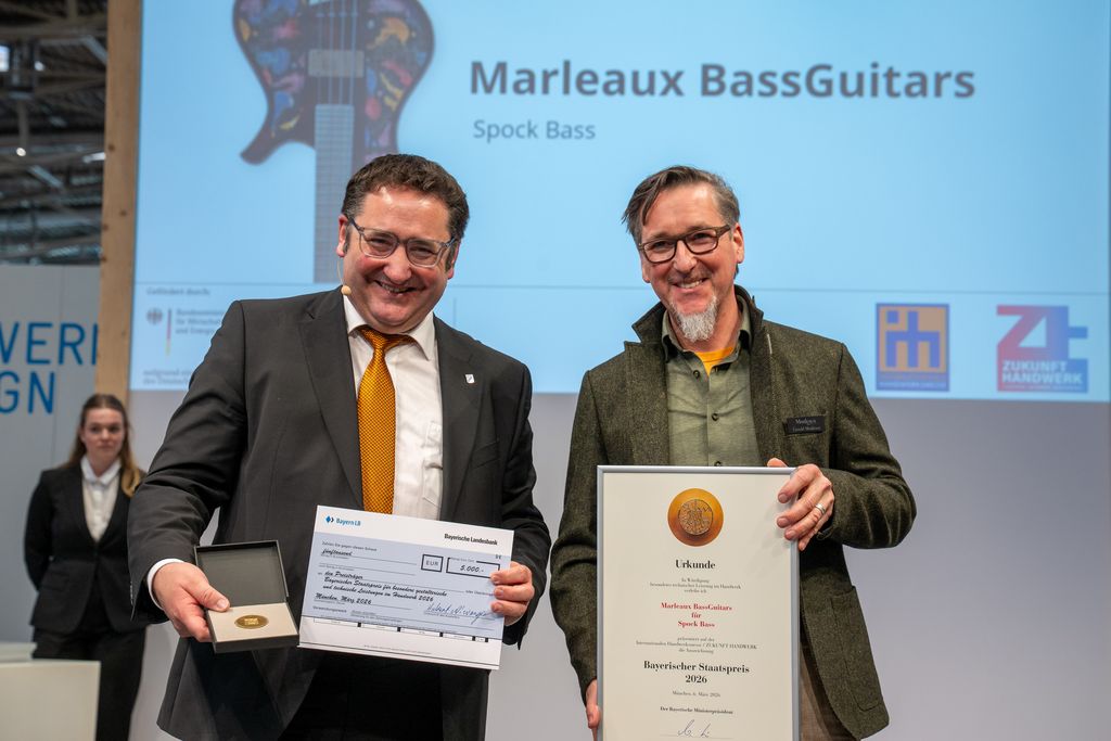 Bayerns Wirtschaftsstaatssekretär Tobias Gotthardt übergibt den Staatspreis an Marleaux BassGuitars.