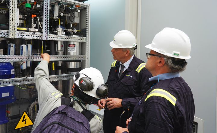 Staatssekretär Roland Weigert (M.) und Prof. Peter Wasserscheid (r.) bei der Besichtigung des ersten Elektrolyseurs für grünen H2 in Kolumbien. Die Anlage steht in der Ecopetrol-Raffinerie in Cartagena. Foto: StMWi.