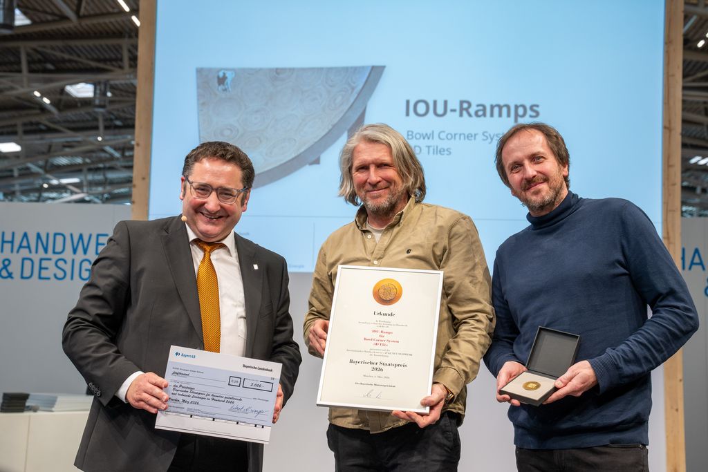 Bayerns Wirtschaftsstaatssekretär Tobias Gotthardt übergibt den Staatspreis an JIOU-Ramps.