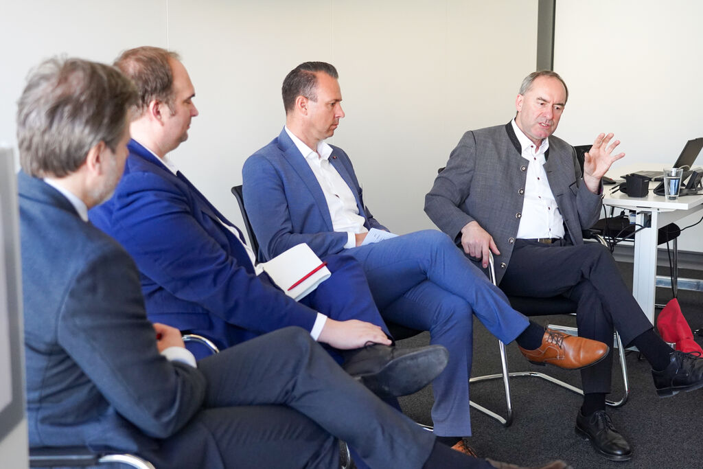 Wirtschafts- und Energieminister Hubert Aiwanger diskutiert mit Sebastian Roloff, MdB (SPD) und einem Vertreter der Chair AG Wind über die Herausforderungen der Windkraftbranche. Foto: StWMi.