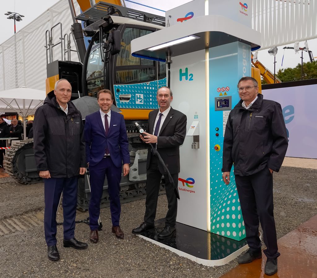 Bayerns Wirtschaftsminister Hubert Aiwanger und der Geschäftsführer der Messe München, Stefan Rummel (zweiter von links) sprachen am bauma-Stand von Liebherr über Wasserstoffantriebe für Großbagger. Foto: Elke Neureuther/StMWi