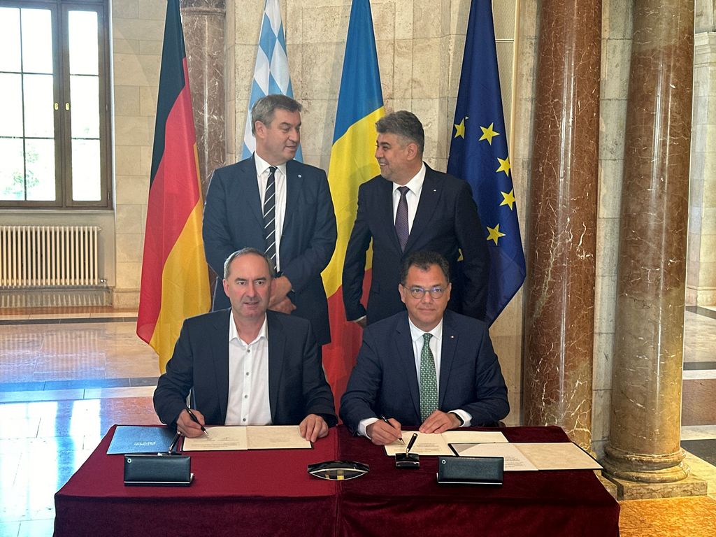 Bayerns Wirtschaftsminister Hubert Aiwanger (links) und seiner rumänischer Amtskollege Stefan-Radu Oprea unterzeichnen die Absichtserklärung zur Stärkung der wirtschaftlichen Zusammenarbeit. Dahinter stehen Ministerpräsident Dr. Markus Söder und Rumäniens Premierminister Ion-Marcel Ciolacu. Foto: StMWi