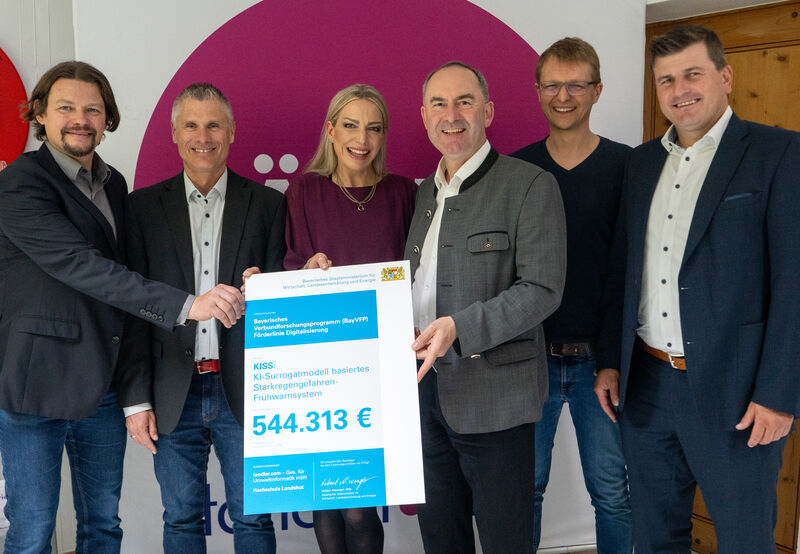 Bayerns Wirtschaftsminister Hubert Aiwanger hat die Förderungurkunde für das Projekt "KISS: KI-Surrogatmodell basiertes Starkregengefahren-Frühwarnsystem" übergeben, an (v.l.n.r.) Dr. Andreas Hofmann (Leiter Forschung bei tandler.com), Gerald Angermair (Technischer Leiter bei tandler.com), Angela Tandler (Geschäftsführerin von tandler.com), Prof. Dr. Christian Osendorfer (Professor für maschinelles Lernen an der Hochschule Landshut) und Johannes Mitterhuber (zweiter Bürgermeister Buch a. Erlbach).
Foto: StMWi