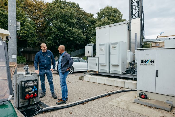 Am Fuße des Funkturms fließen die Daten ins Münchner Glasfasernetz. Lars Spinger (links) von der Firma Abel aus dem Landkreis Traunstein und Telefónica-Funknetzplaner Andreas Illgen prüfen die Installation.