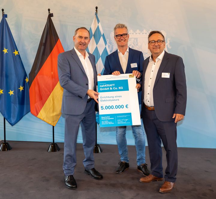Energieminister Hubert Aiwanger überreicht Patrick Ruh, 1. Bürgermeister der Stadt Feuchtwangen (2.v.l.) und Lothar Beckler, Geschäftsführer der Stadtwerke Feuchtwangen (3.v.l.), den Förderbescheid für das Projekt nahKRAFT zum Bau eines Elektrolyseurs.
Foto: StMWi/E. Neureuther