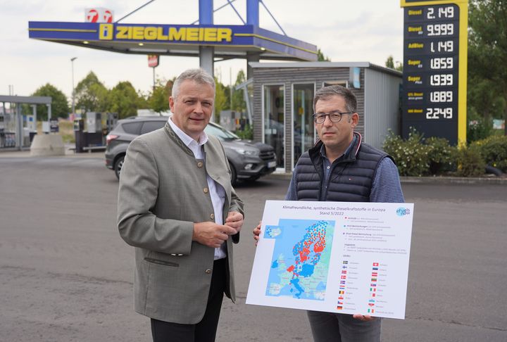 Nico Zieglmeier zeigt Wirtschaftsstaatssekretär Roland Weigert (l.), dass HVO100 europaweit bereits an über 1.100 Tankstellen erhältlich ist, nur nicht in Deutschland. Foto: StMWi