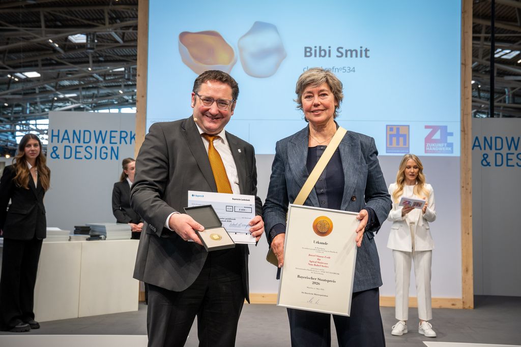 Bayerns Wirtschaftsstaatssekretär Tobias Gotthardt übergibt den Staatspreis an Bibi Smit.