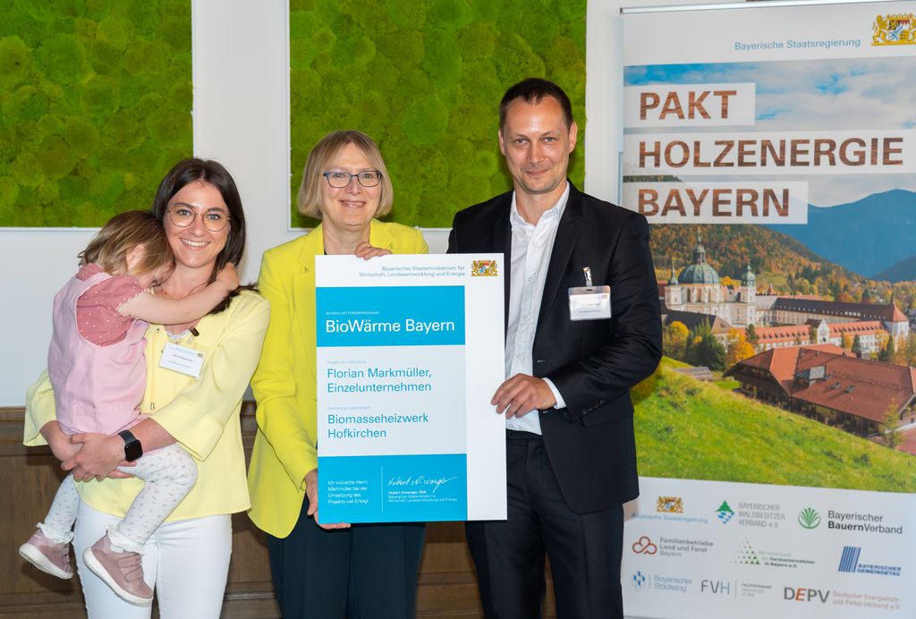 Amtschefin Dr. Sabine Jarothe (Mitte) hat im Wirtschaftsministerium einige Projektinitiativen, die über das Förderprogramm "BioWärme Bayern" gefördert werden, besonders gewürdigt. Die Projektverantwortlichen Florian und Marina Markmüller mit Tochter nahmen die Förderurkunde entgegen. Foto: StMWi/Bastian Brummer