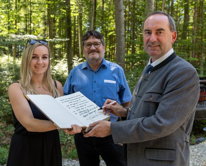 Wirtschaftsminister Hubert Aiwanger (rechts) trägt sich in das Goldene Buch der Gemeinde Fuchstal ein 