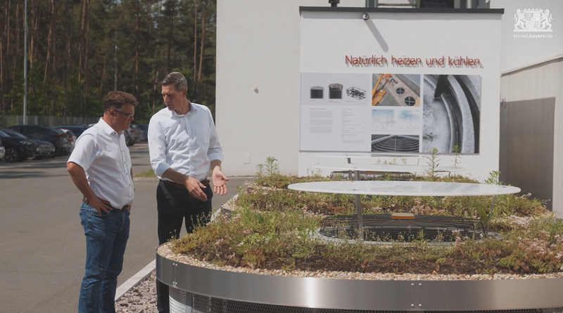 Zwei Preisträger des Bayerischen Energiepreises stehen vor einem Luft-Eisspeicher