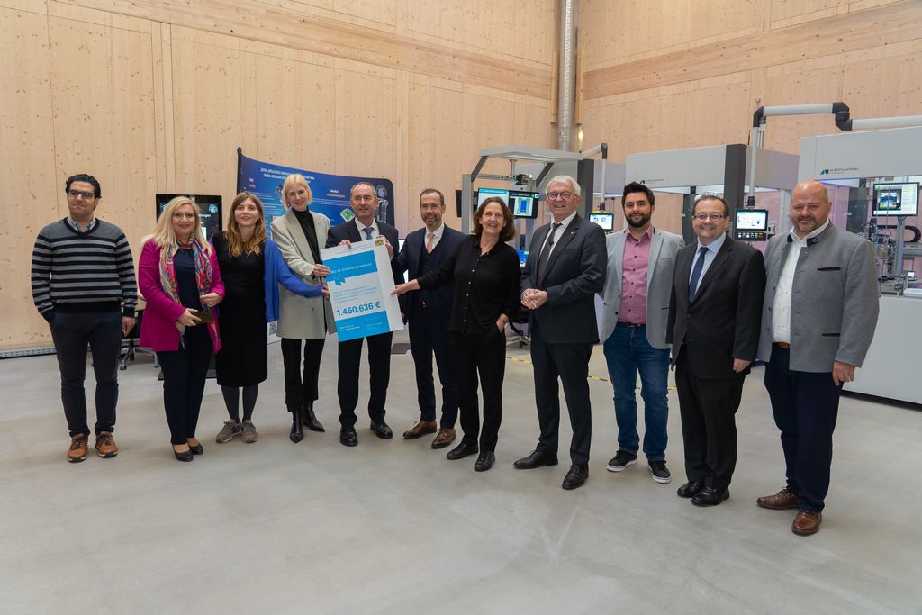 Im Anschluss an den Spatenstich übergab der Minister einen Förderbescheid über 1,5 Millionen Euro an die Universität Bamberg zur Fortsetzung des KMU-KI-Erfahrungszentrums. Das Bild zeigt den Minister mit Vertretern der Universität sowie aus der Landes- und Kommunalpolitik. Foto: StMWi/Bastian Brummer