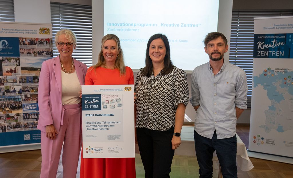 Staatssekretärin Anna Stolz übergibt Gudrun Donaubauer (li.), Erste Bürgermeisterin der Stadt Hauzenberg, Theresa Lenz (Wirtschaftsförderung Stadt Hauzenberg) und Dr. Peter Görgl (Modul5 GmbH) die Teilnahmeurkunde. Foto: StMWi