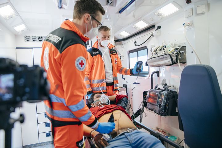 Notfallsanitäter Gabriel Hümmer (links) und sein Kollege Leon Bösl untersuchen den Patienten mit einem Ultraschallgerät. Über ein Smartphone und 5G-Mobilfunk wird das Bild in Echtzeit in die Klinik übertragen. 