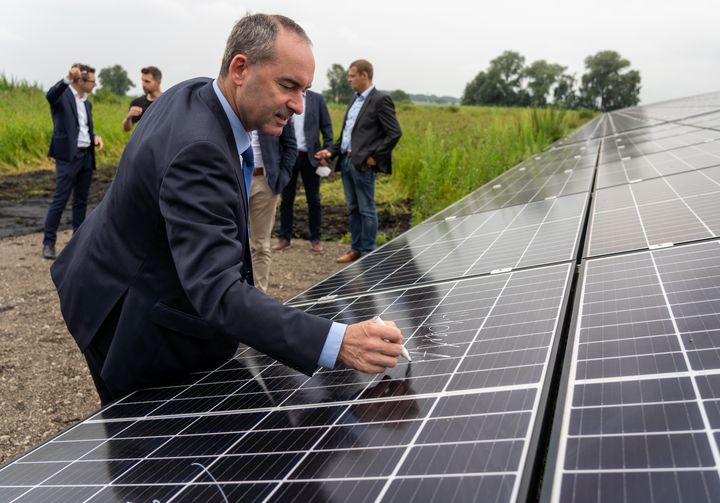 Bayerns Wirtschafts- und Energieminister Hubert Aiwanger setzt seine Unterschrift auf das letzte PV-Panel.