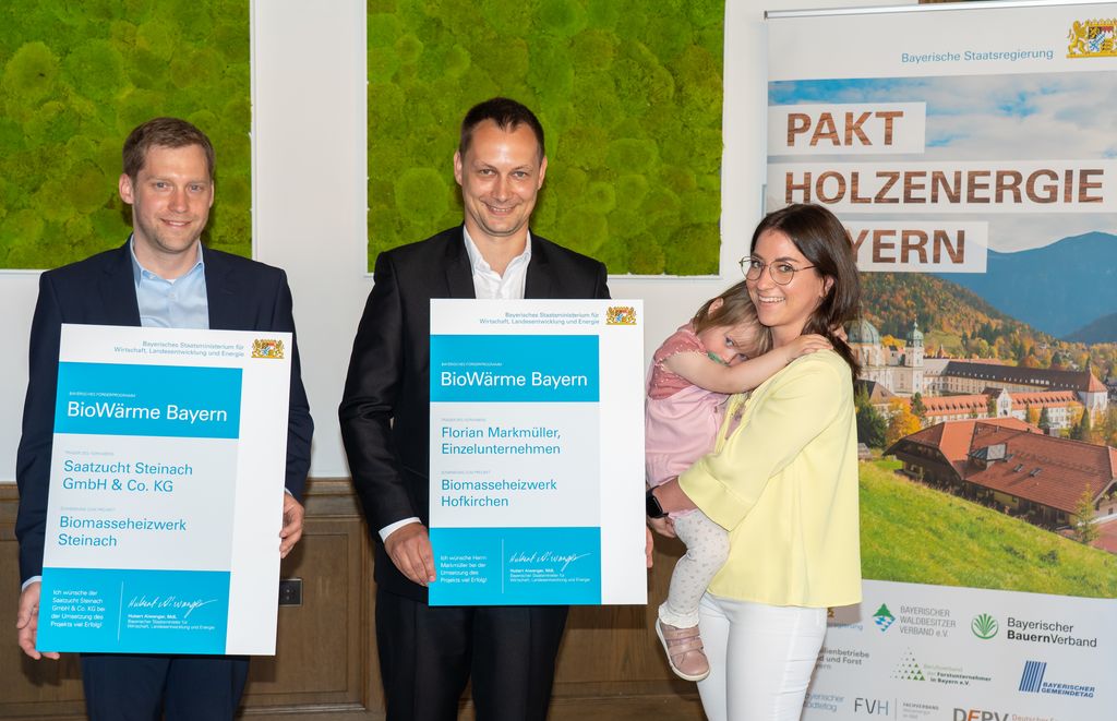 Die Verantwortlichen für die jüngst geförderten Projekte aus Niederbayern (v.l.n.r): Julian Broscheit (Saatzucht Steinach GmbH & Co. KG), Florian und Marina Markmüller mit Tochter vom Biomasseheizwerk Hofkirchen. Foto: StMWi/Bastian Brummer